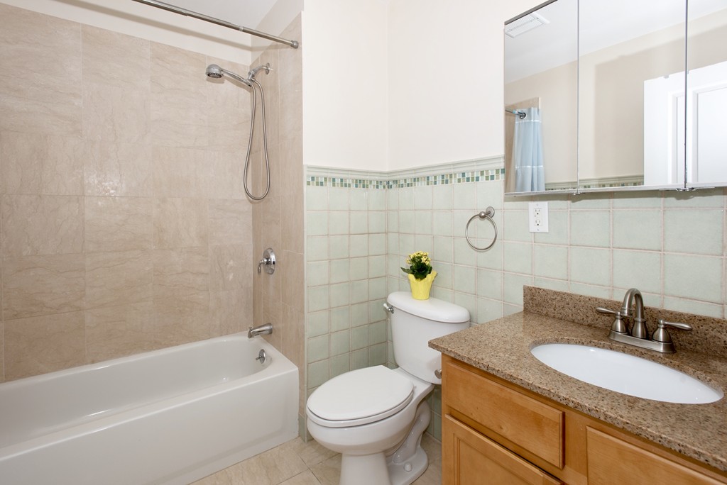 11 Cheriton Road, Unit 307 Boston, MA 02132 - Photo 8 of 12 a bathroom with a granite countertop toilet a sink and a bathtub