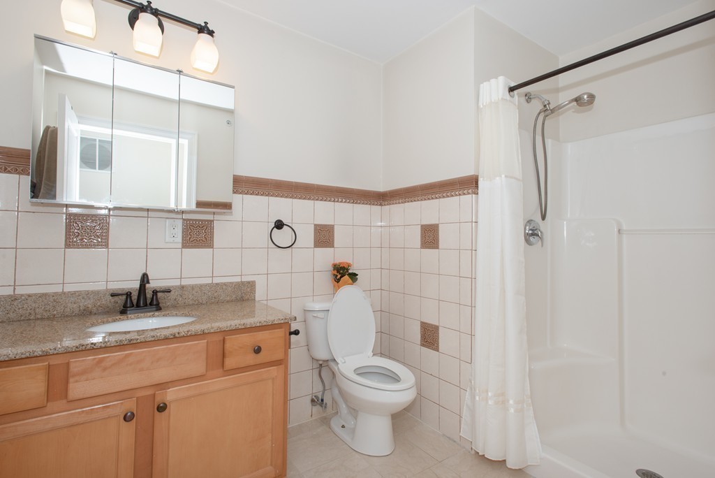 11 Cheriton Road, Unit 307 Boston, MA 02132 - Photo 9 of 12 a bathroom with a granite countertop sink toilet and shower