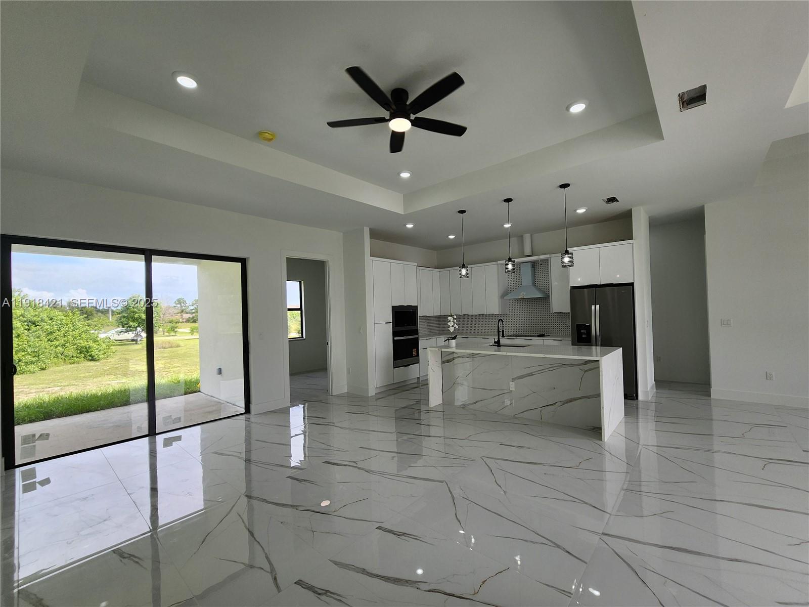 3302 East 18th Street, Unit ST Lehigh Acres, FL 33972 - Photo 11 of 34 a view of open kitchen with kitchen island stainless steel appliances refrigerator oven dining table and chairs