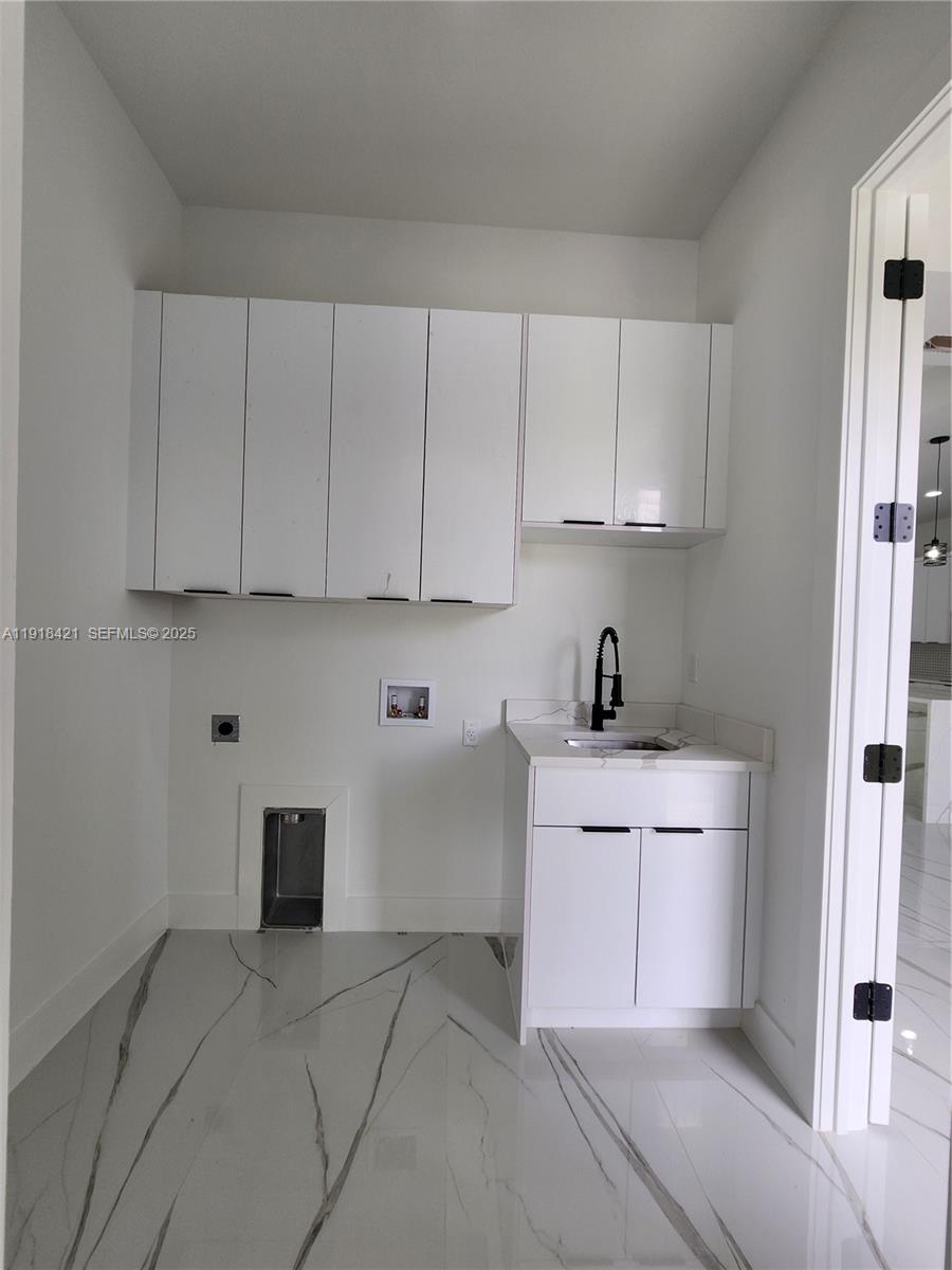 3302 East 18th Street, Unit ST Lehigh Acres, FL 33972 - Photo 17 of 34 a kitchen with stainless steel appliances granite countertop a sink and cabinets with wooden floor