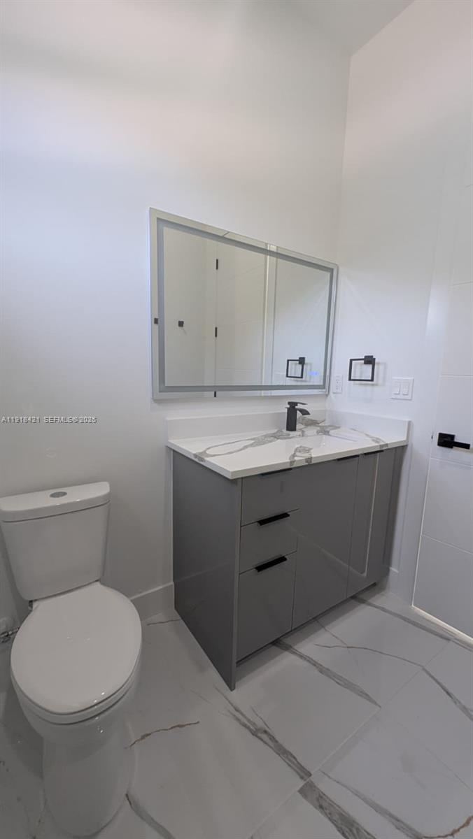 3302 East 18th Street, Unit ST Lehigh Acres, FL 33972 - Photo 29 of 34 a bathroom with a sink a toilet and vanity