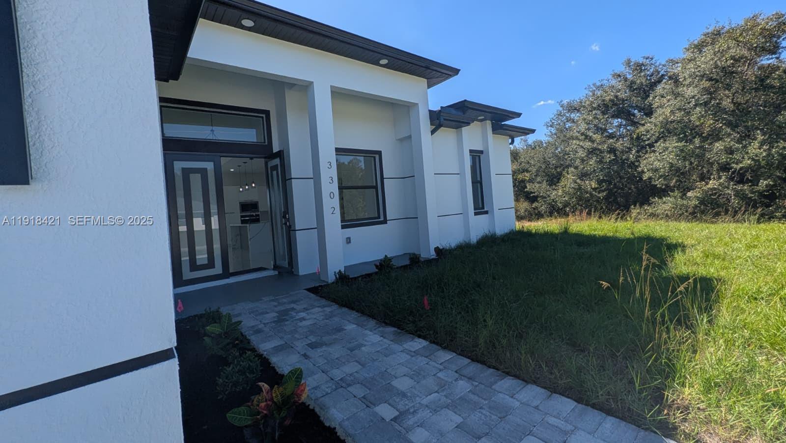 3302 East 18th Street, Unit ST Lehigh Acres, FL 33972 - Photo 3 of 34 a backyard of a house with lots of green space
