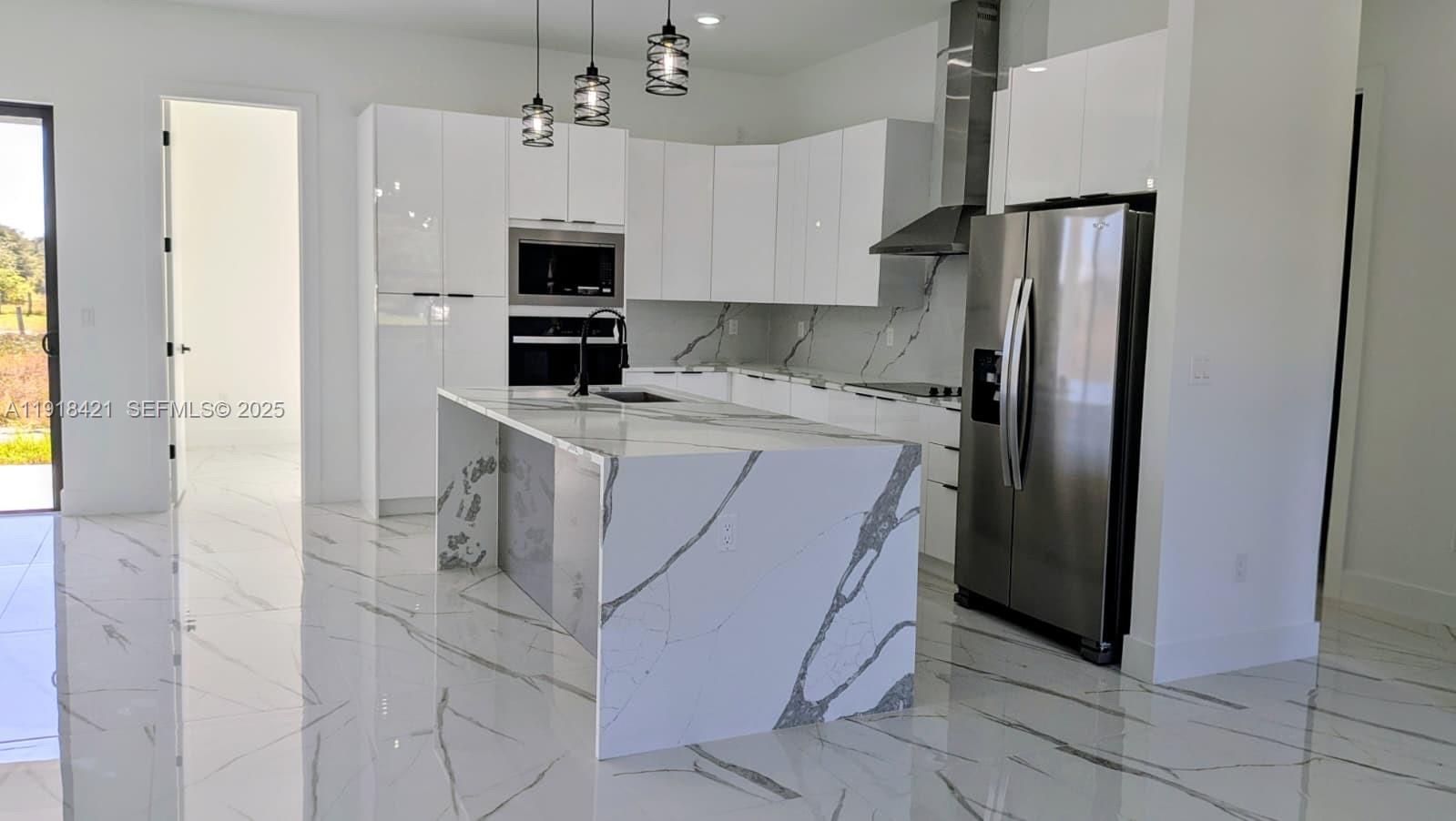 3302 East 18th Street, Unit ST Lehigh Acres, FL 33972 - Photo 7 of 34 a kitchen with stainless steel appliances a refrigerator sink and microwave