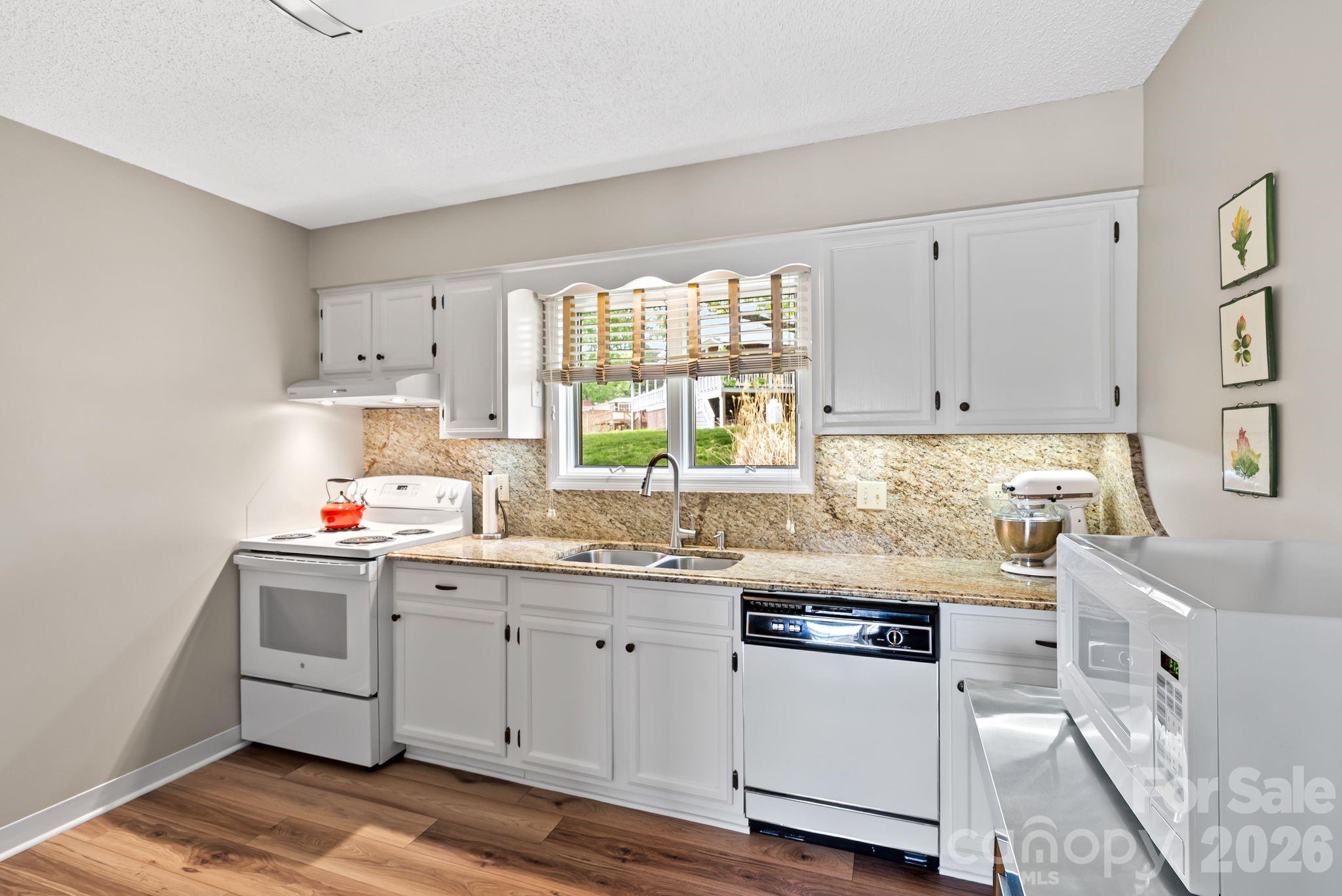 108 Kyfields Weaverville, NC 28787 - Photo 6 of 32 a kitchen with granite countertop white cabinets sink and white appliances