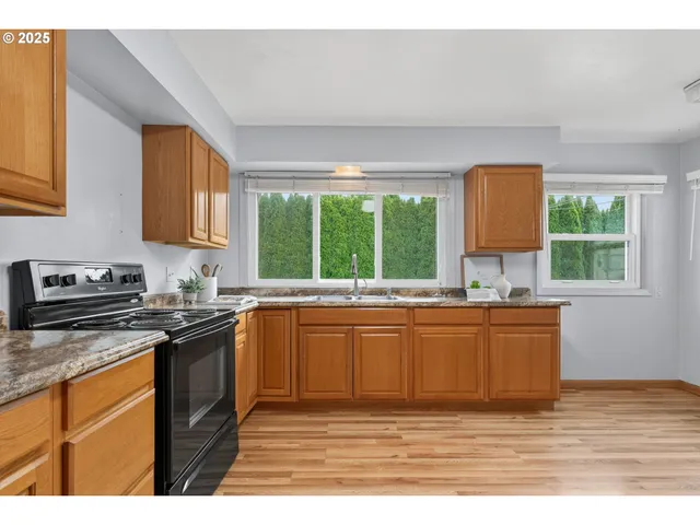 a kitchen with stainless steel appliances granite countertop a stove a sink dishwasher and a refrigerator