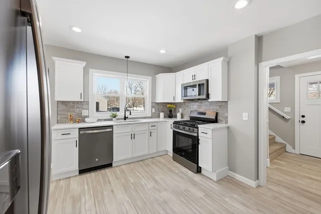 a kitchen with granite countertop a refrigerator stove top oven and sink