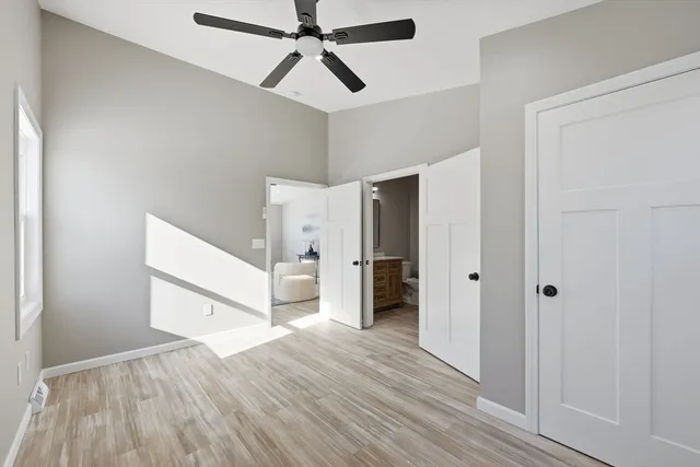 a view of a hallway with a ceiling fan and wooden floor