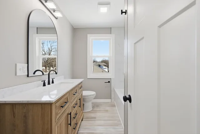 a bathroom with a double vanity sink a mirror and a toilet