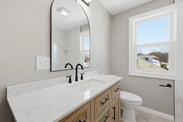 a bathroom with a sink a toilet and a mirror