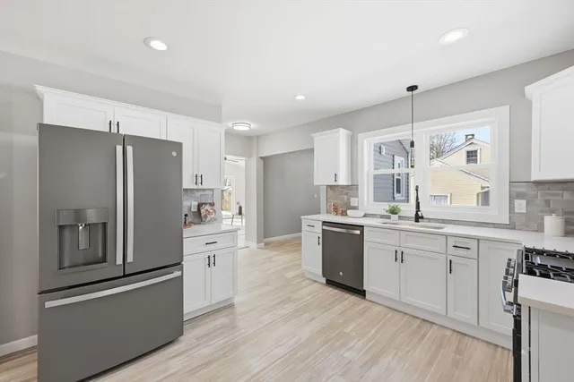 a kitchen with white cabinets and stainless steel appliances