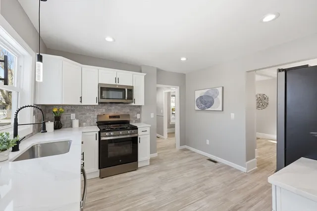a kitchen with granite countertop a refrigerator stove and sink