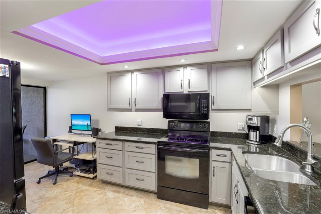 1782 Imperial Golf Course Boulevard, Unit C104 Naples, FL 34110 - Photo 11 of 34 a kitchen with a stove a sink and a refrigerator