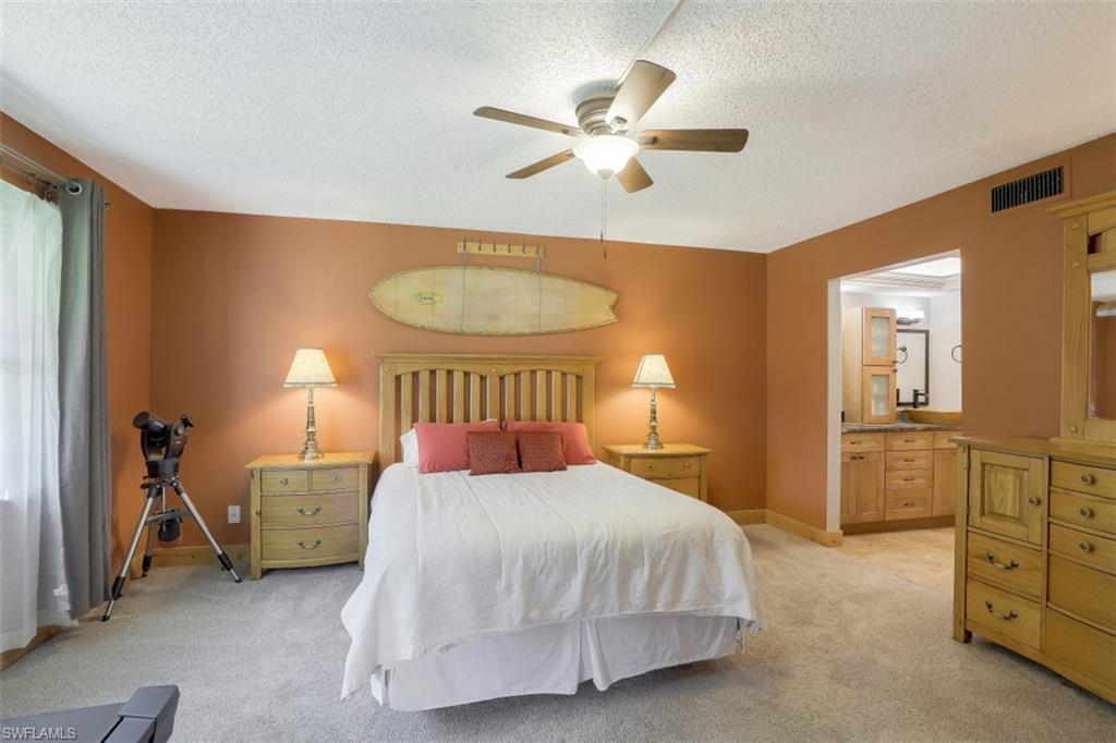 1782 Imperial Golf Course Boulevard, Unit C104 Naples, FL 34110 - Photo 13 of 34 a bedroom with a bed and a chandelier