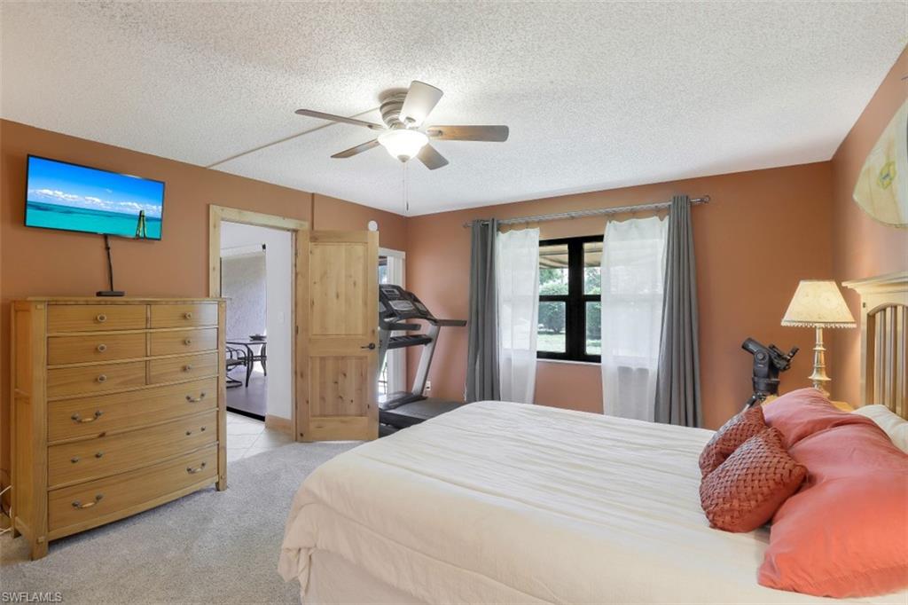 1782 Imperial Golf Course Boulevard, Unit C104 Naples, FL 34110 - Photo 14 of 34 a bedroom with a bed and a chandelier