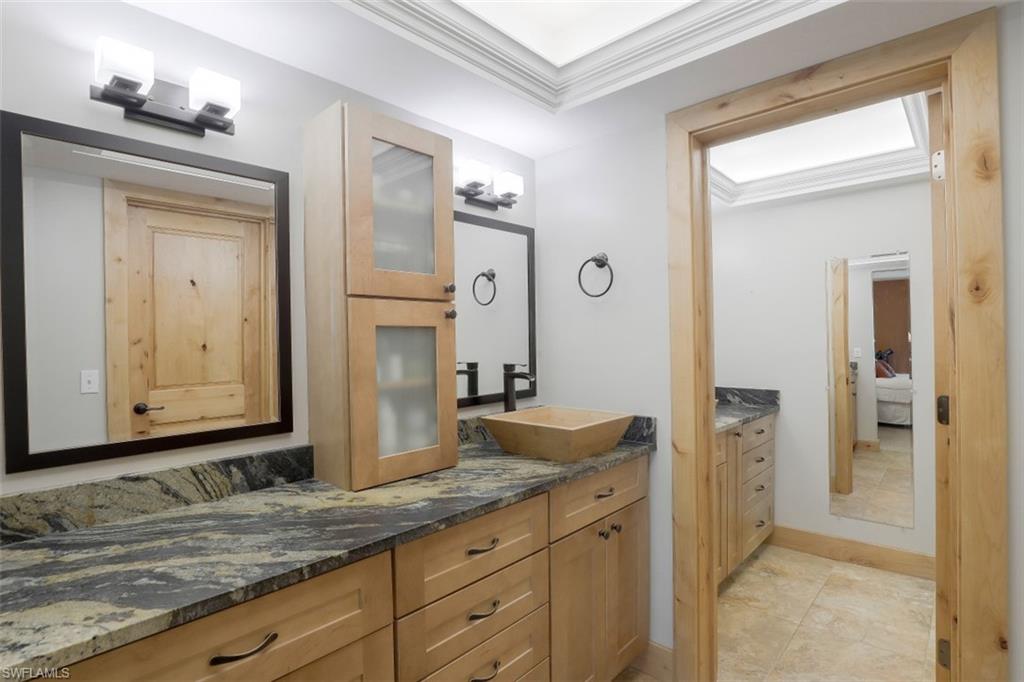 1782 Imperial Golf Course Boulevard, Unit C104 Naples, FL 34110 - Photo 15 of 34 a bathroom with a granite countertop sink and a mirror