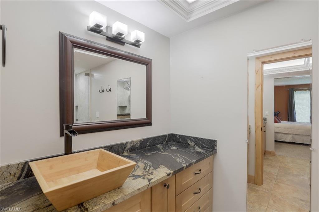 1782 Imperial Golf Course Boulevard, Unit C104 Naples, FL 34110 - Photo 16 of 34 a bathroom with a sink a mirror and vanity