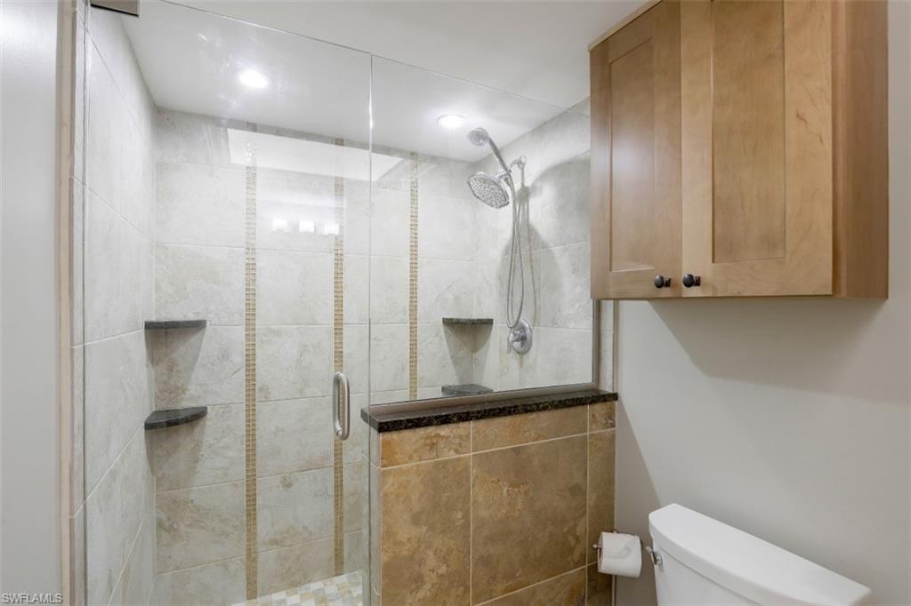 1782 Imperial Golf Course Boulevard, Unit C104 Naples, FL 34110 - Photo 17 of 34 a bathroom with a shower and a toilet