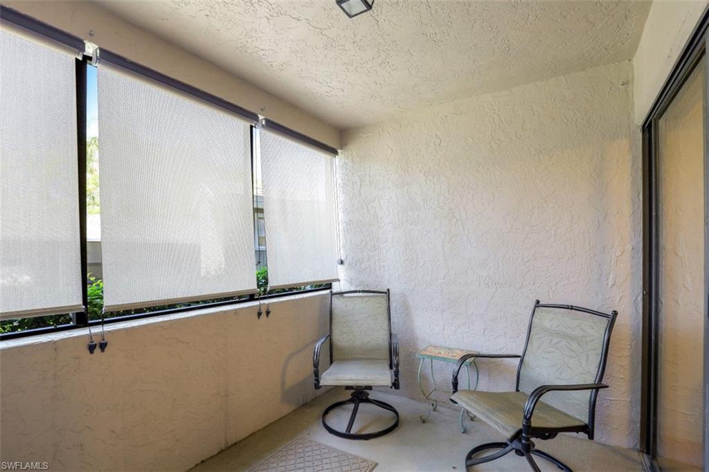 1782 Imperial Golf Course Boulevard, Unit C104 Naples, FL 34110 - Photo 21 of 34 a room with a chair and mirror