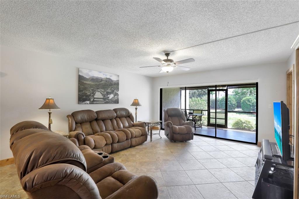 1782 Imperial Golf Course Boulevard, Unit C104 Naples, FL 34110 - Photo 3 of 34 a living room with furniture ceiling fan and a floor to ceiling window