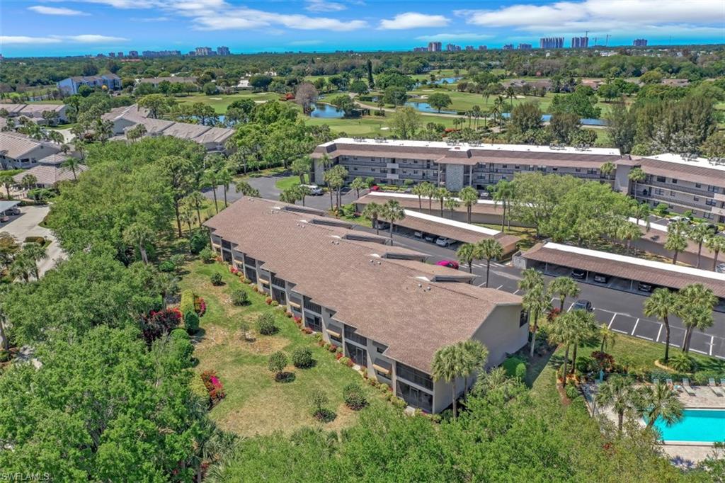 1782 Imperial Golf Course Boulevard, Unit C104 Naples, FL 34110 - Photo 33 of 34 an aerial view of a house with a yard and lake view