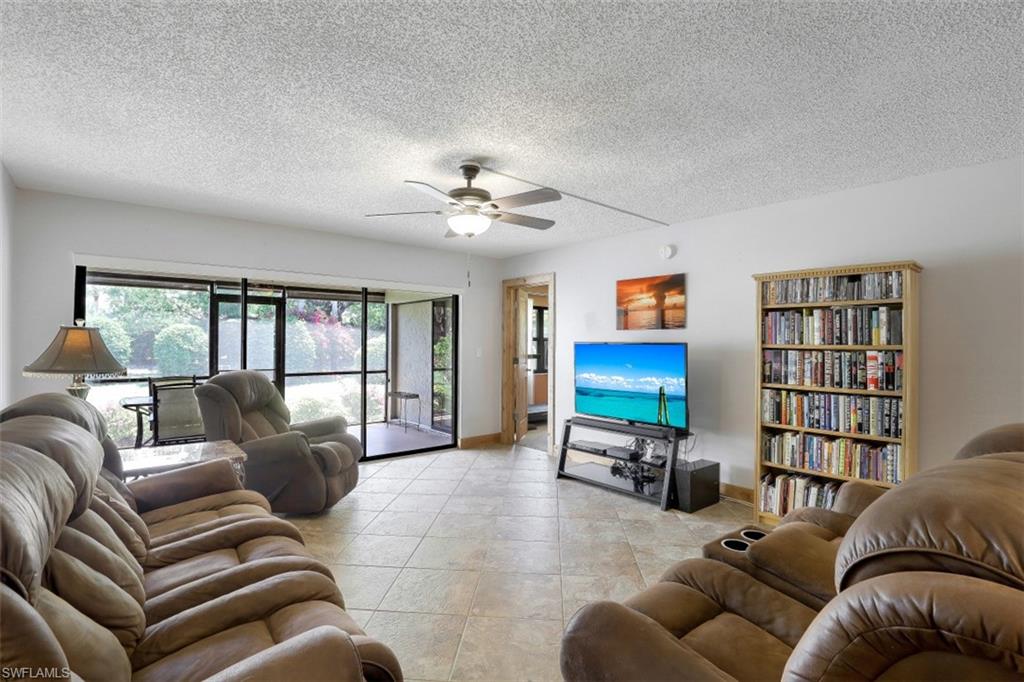 1782 Imperial Golf Course Boulevard, Unit C104 Naples, FL 34110 - Photo 4 of 34 a living room with furniture ceiling fan and a window