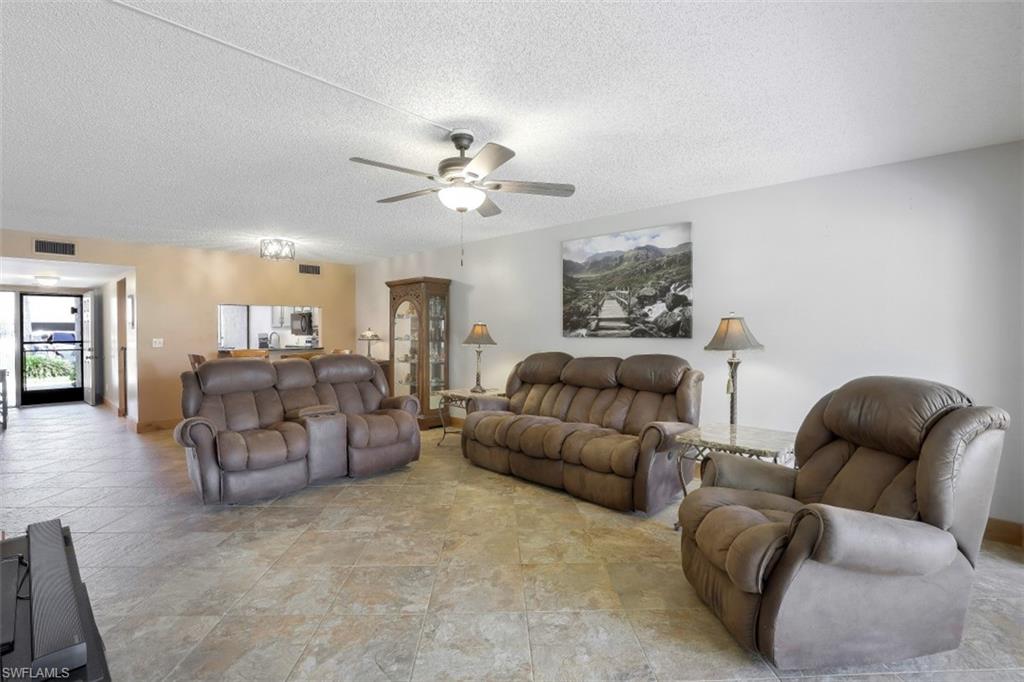 1782 Imperial Golf Course Boulevard, Unit C104 Naples, FL 34110 - Photo 7 of 34 a living room with furniture and wooden floor