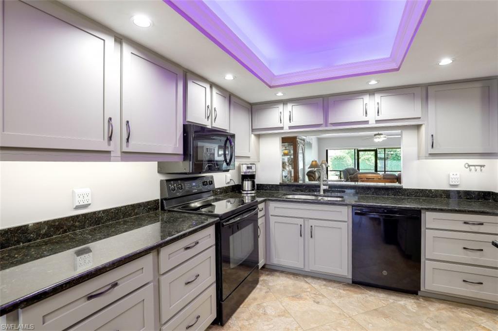 1782 Imperial Golf Course Boulevard, Unit C104 Naples, FL 34110 - Photo 8 of 34 a kitchen with stainless steel appliances granite countertop a sink stove and cabinets
