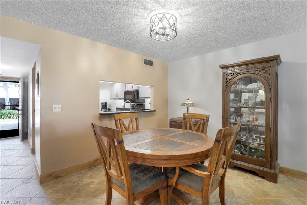 1782 Imperial Golf Course Boulevard, Unit C104 Naples, FL 34110 - Photo 10 of 34 a view of a dining room with furniture