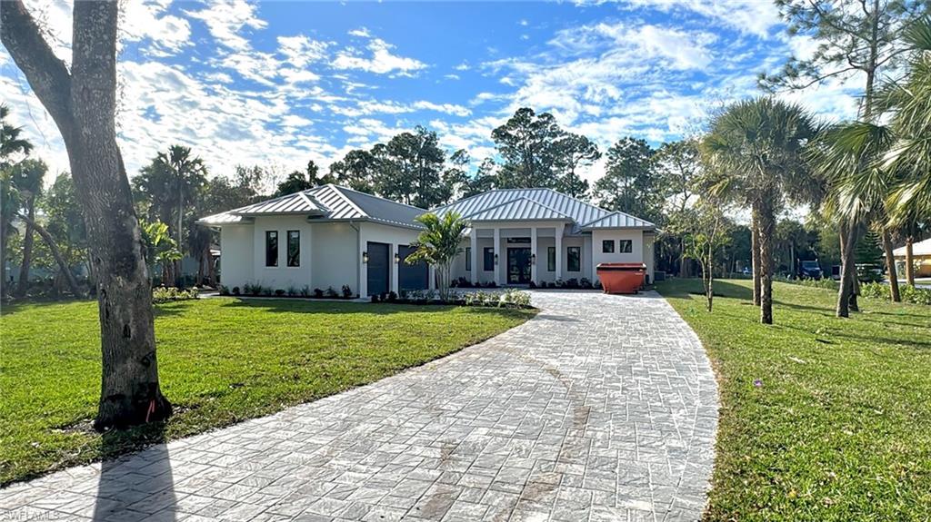 1109 15th Street Southwest Naples, FL 34117 - Photo 2 of 4 a front view of a house with a yard