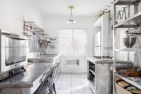 a kitchen with kitchen island granite countertop a sink stove and cabinets