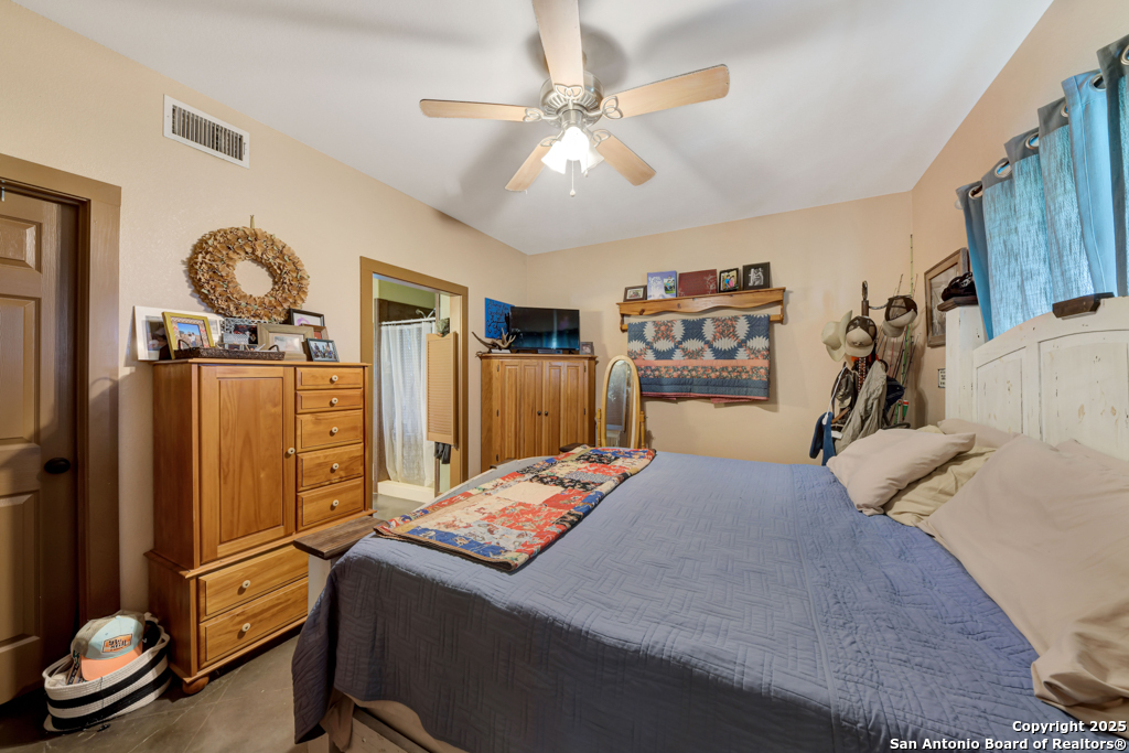 4190 Atkins Road Salado, TX 76571 - Photo 28 of 49 a bedroom with a bed and a flat tv screen on the dresser