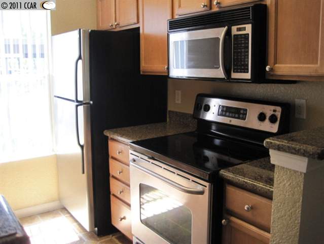110 Reflections Drive, Unit 13 San Ramon, CA 94583 - Photo 1 of 1 a kitchen with granite countertop a refrigerator stove and microwave