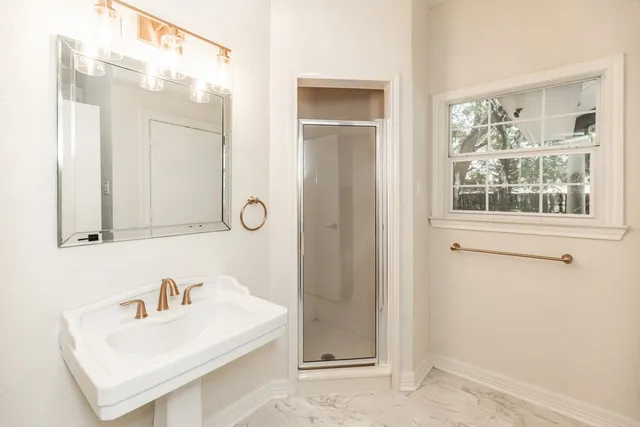 a bathroom with a sink a mirror and a shower