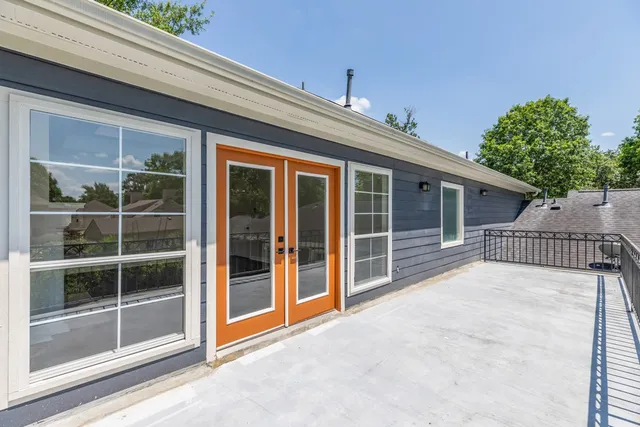 a view of a house with a large window and wooden fence