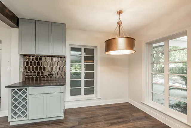 a kitchen with a refrigerator and wooden floor