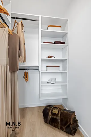 a view of walk in closet with clothes and shoes