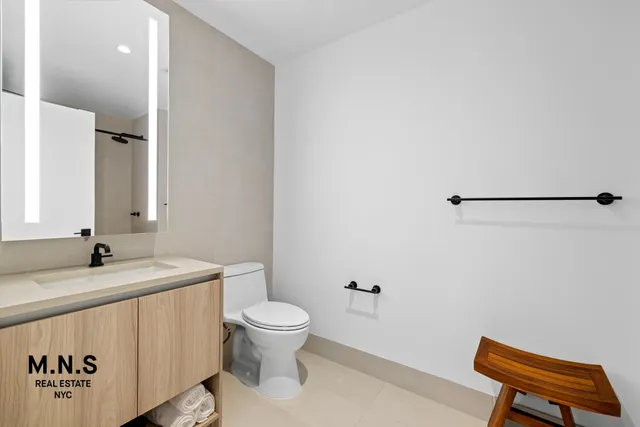 a bathroom with a granite countertop sink and a toilet