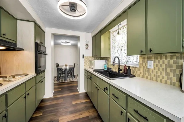 a kitchen with stainless steel appliances granite countertop a sink and a stove