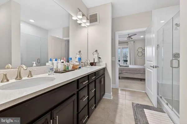 a bathroom with a sink double vanity granite tub and shower