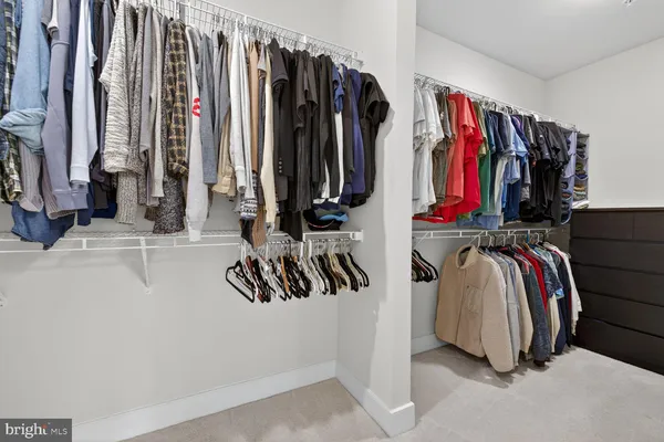 a view of walk in closet with clothes and shoes