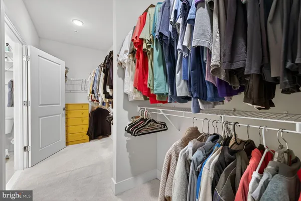 a view of walk in closet with clothes and shoes