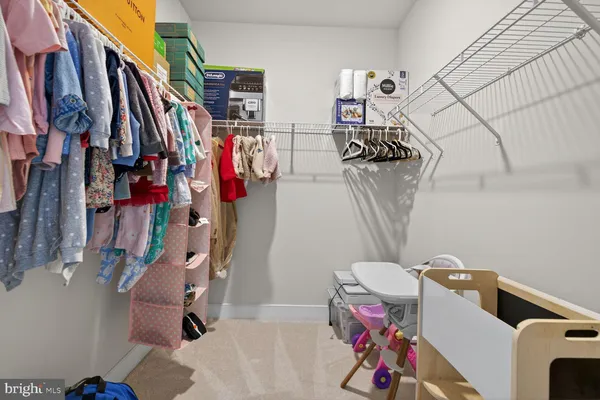 a view of walk in closet with clothes and shoes