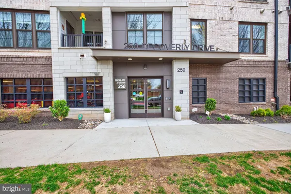 a front view of a building with a garden and plants
