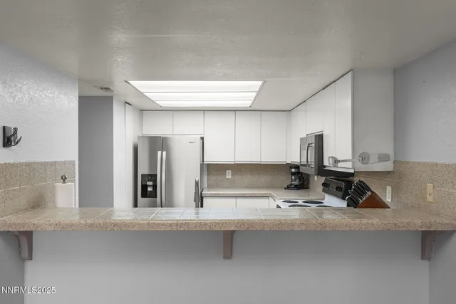 a kitchen with stainless steel appliances a sink and cabinets