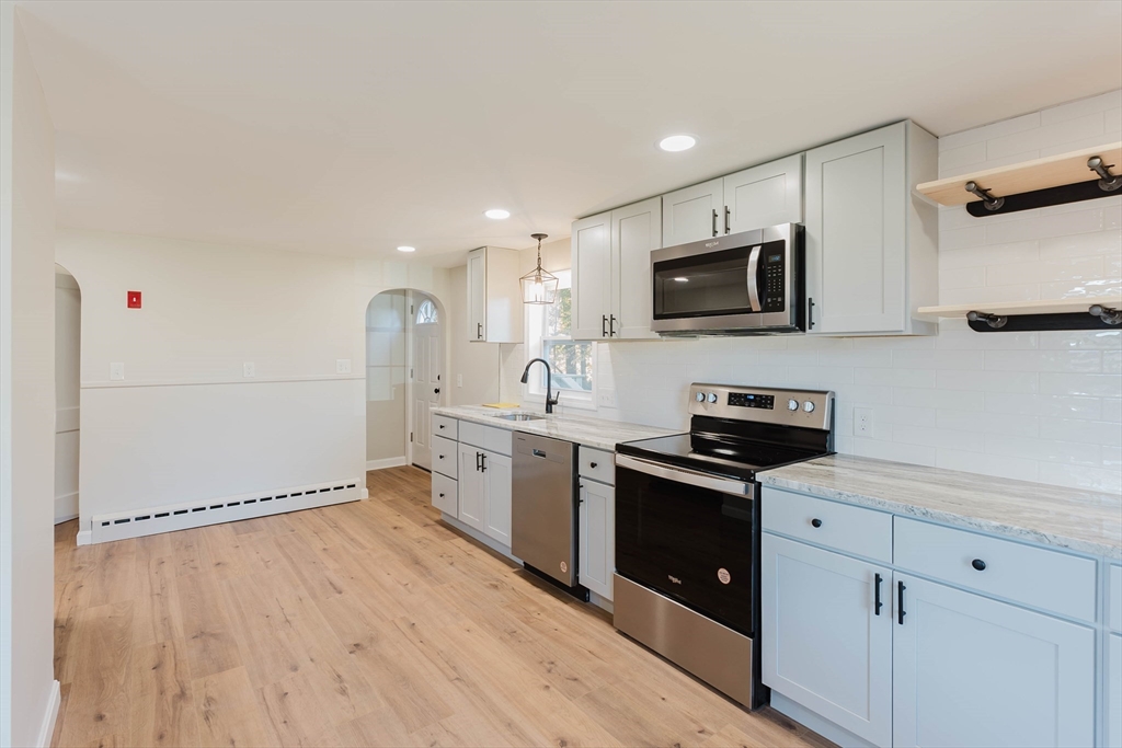 28 Thompson Road Webster, MA 01570 - Photo 6 of 30 a open kitchen with stainless steel appliances granite countertop a refrigerator oven a sink dishwasher and white cabinets with wooden floor