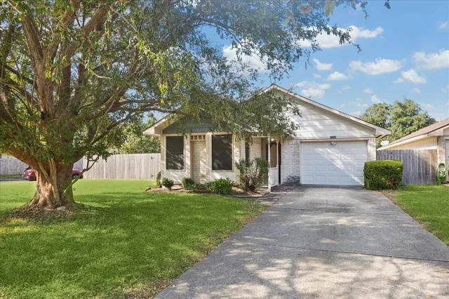 a view of a house with backyard and a tree