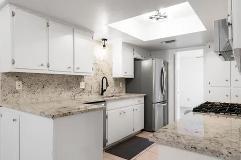 a kitchen with stainless steel appliances granite countertop a sink stove and refrigerator