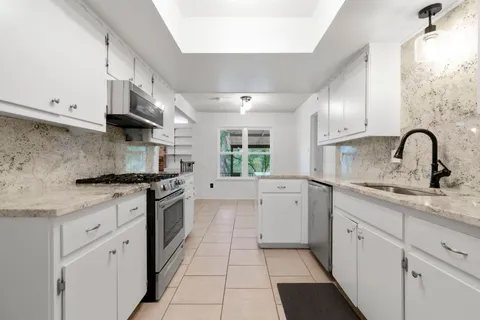 a kitchen with a sink stove and cabinets