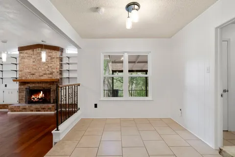 a view of an empty room with window and fire place