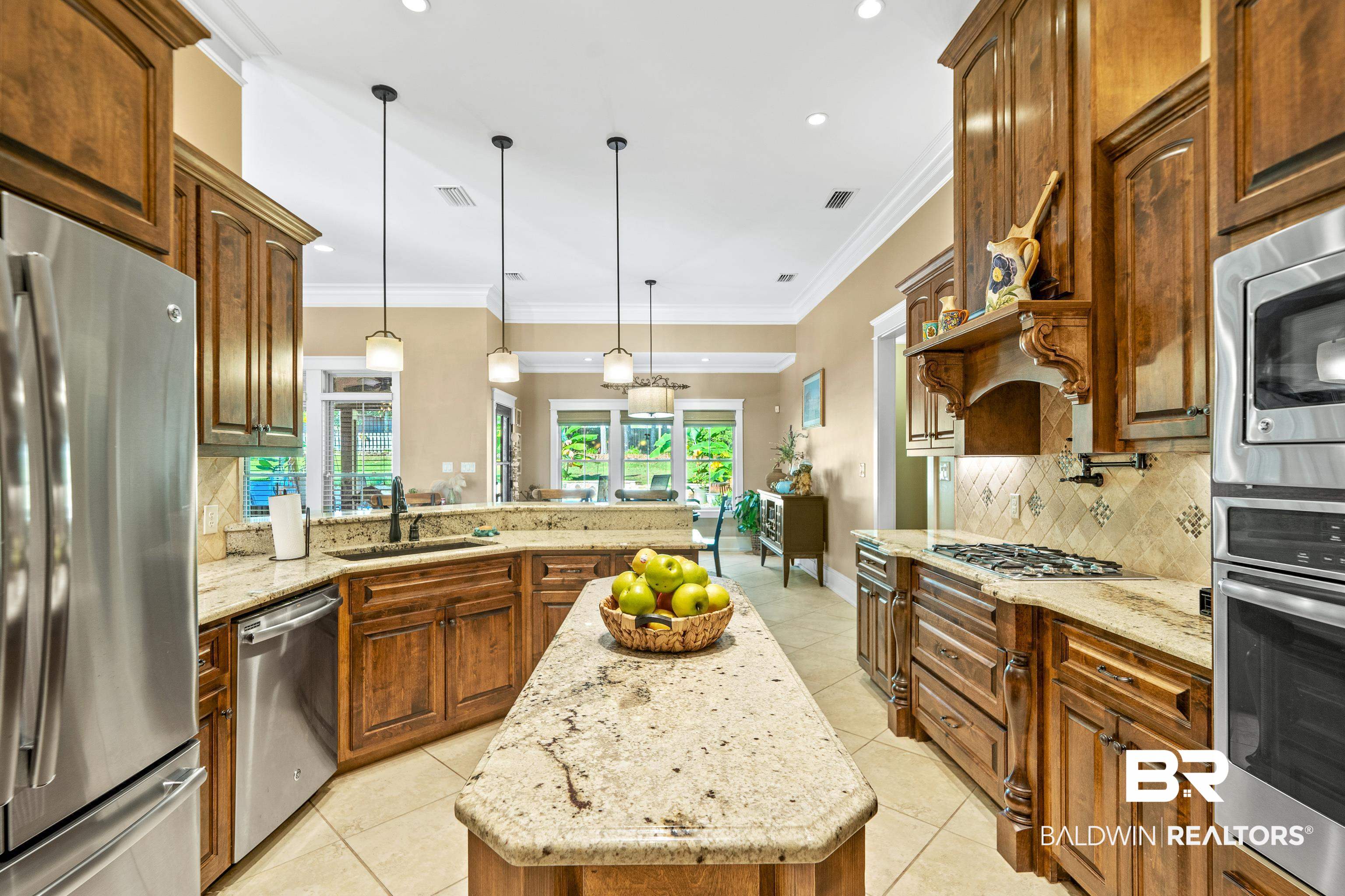 31829 Butler Drive Daphne, AL 36527 - Photo 18 of 48 Kitchen with light stone counters, pendant lighting, appliances with stainless steel finishes, and a kitchen island
